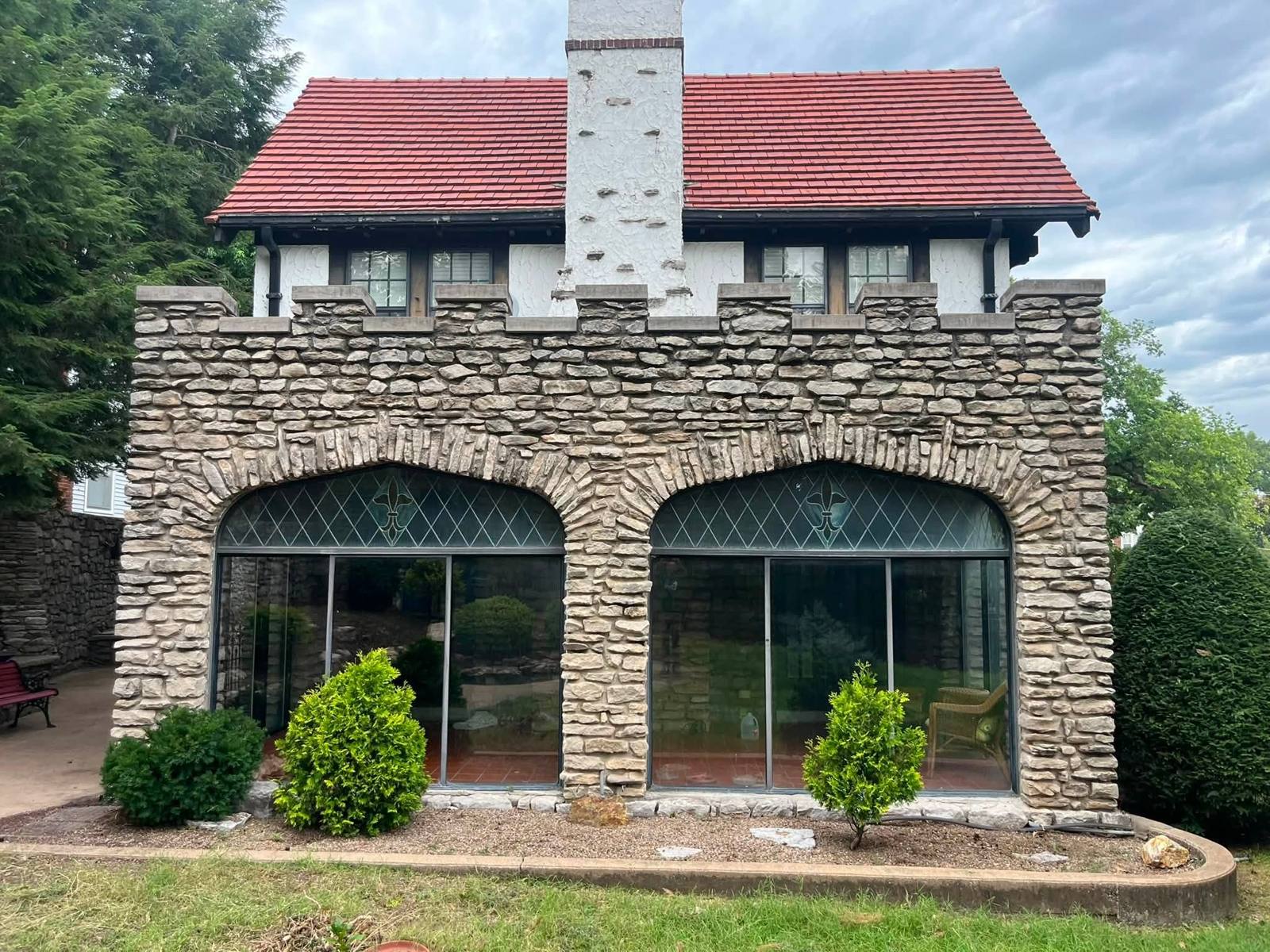 Stone garden room with trimmed shrubs and a gravel bed