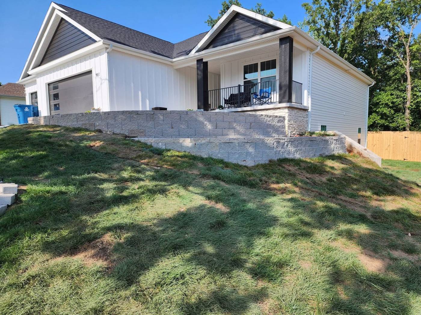 Two-tier stone retaining wall landscaping below a new home